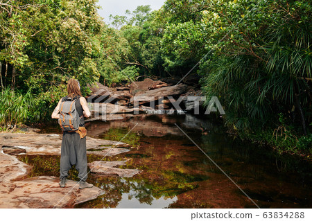 Tourist looking at river Tourist looking at river 63834288