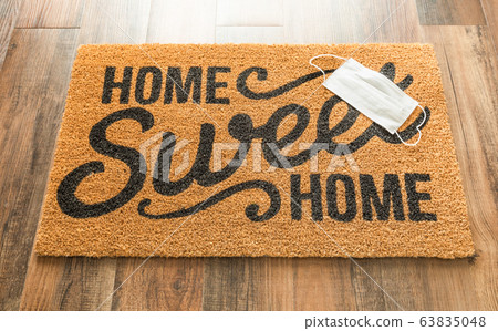 One Medical Face Mask Rests on Home Sweet Home Mat 63835048