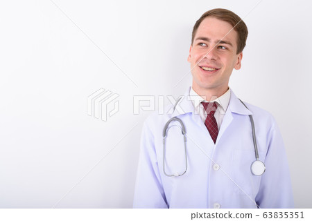 Young handsome man doctor against white background Young handsome man doctor against white background 63835351