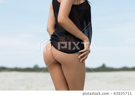 Crop woman with firm buttocks on beach 63835711