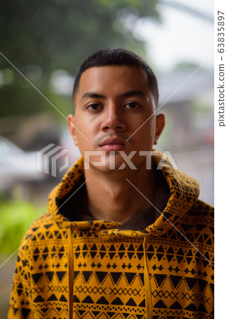 Young multi-ethnic Asian man in the streets outdoors Young multi-ethnic Asian man in the streets outdoors 63835897