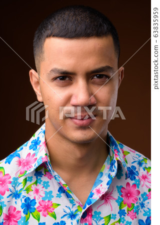 Young multi-ethnic Asian tourist man against brown background 63835959