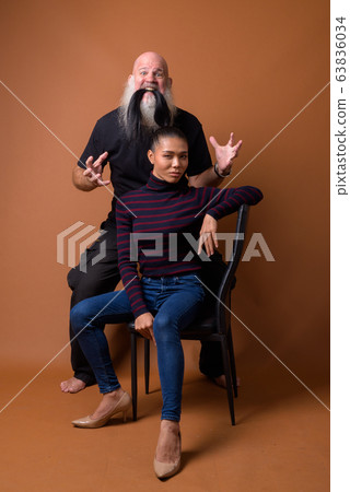 Mature bearded bald man with young Asian transgender woman Mature bearded bald man with young Asian transgender woman 63836034