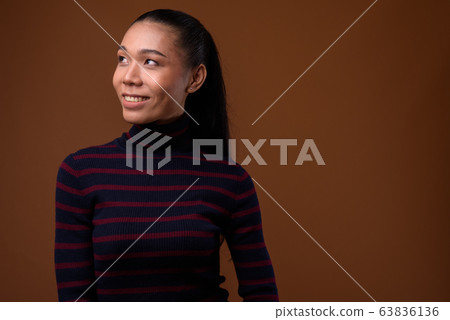 Young beautiful Asian transgender woman against brown background Young beautiful Asian transgender woman against brown background 63836136