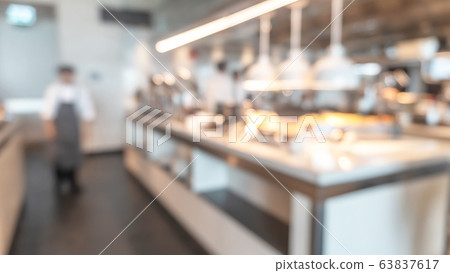 Buffet at hotel restaurant interior blur background with blurry open kitchen counter bar of food catering service business with chef staff cooking for breakfast, lunch or dinner meal 63837617