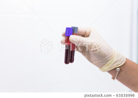 Covid-19, pandemic and coronavirus concept - hand holding blood in tests tubes close up, white background with copy space. Covid-19, pandemic and coronavirus concept - hand holding blood in tests tubes close up, white background with copy space. 63838996