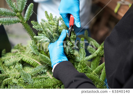 A woman decorates a Christmas arrangement. Master class on making decorative ornaments. Christmas decor with their own hands. The new year celebration. Flower shop 63840140