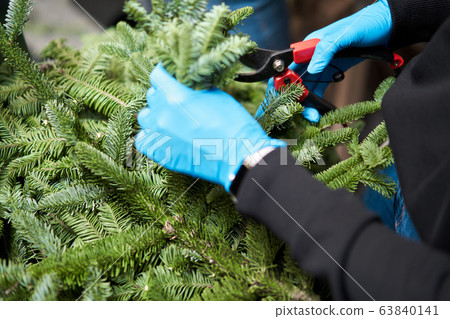 A woman decorates a Christmas arrangement. Master class on making decorative ornaments. Christmas decor with their own hands. The new year celebration. Flower shop 63840141