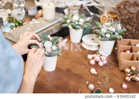 A woman decorates a Christmas arrangement. Master class on making decorative ornaments. Christmas decor with their own hands. The new year celebration. Flower shop 63840142