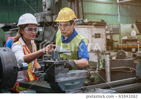 Man and woman engineer industry worker wearing hard hat in factory. Man and woman engineer industry worker wearing hard hat in factory. 63841082