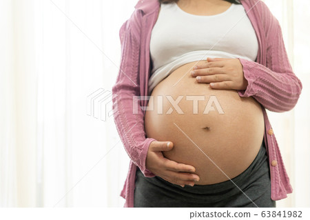 Happy pregnant woman and expecting baby at home. Happy pregnant woman and expecting baby at home. 63841982
