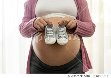 Happy pregnant woman and expecting baby at home. Happy pregnant woman and expecting baby at home. 63841983