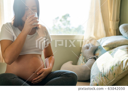 Happy pregnant woman and expecting baby at home. 63842030
