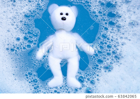 Soaking bear toy in laundry detergent water 63842065