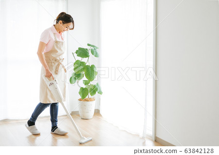 A woman cleaning a vacuum cleaner A woman cleaning a vacuum cleaner 63842128