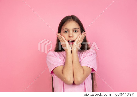 Caucasian little girl portrait isolated on pink studio background, emotions concept 63844387
