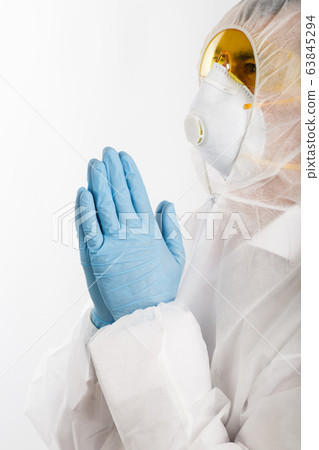 Doctor in anti-epidemic suit praying on white 63845294