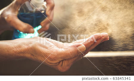 spraying hand sanitizer coronavirus prevention 63845341