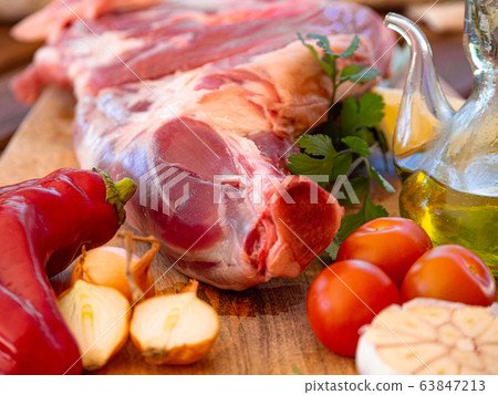 Fresh and raw meat. Leg of lamb on wood background 63847213