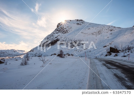 Sunshine on snowy mountain with rural road on Sunshine on snowy mountain with rural road on 63847570