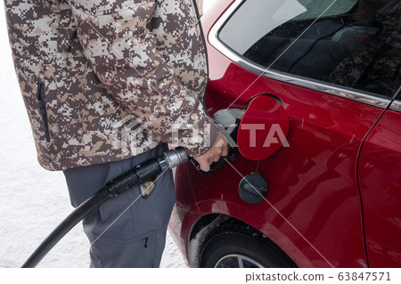 Man holding fuel pump nozzle with filling benzine Man holding fuel pump nozzle with filling benzine 63847571
