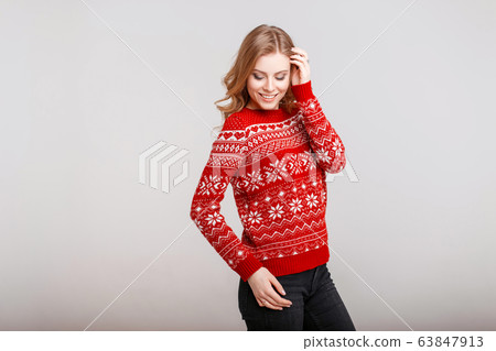 Happy young woman in a trendy red sweater Happy young woman in a trendy red sweater 63847913