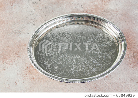 Antique silver plated tray on concrete background. Antique silver plated tray on concrete background. 63849929