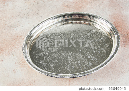 Antique silver plated tray on concrete background. Antique silver plated tray on concrete background. 63849943
