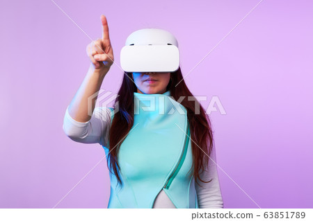 Woman is using virtual reality headset. 63851789