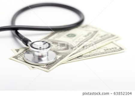 stethoscope placed on banknotes on a white stethoscope placed on banknotes on a white 63852104