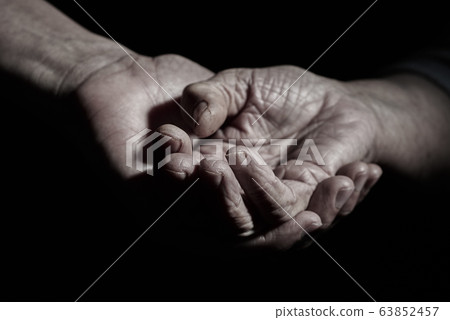 young man holding the hand of a senior woman 63852457