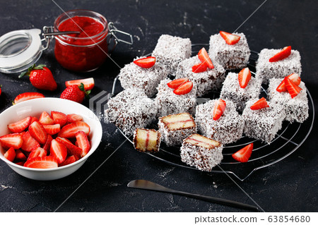 Lamingtons with strawberry jam on a wire rack Lamingtons with strawberry jam on a wire rack 63854680