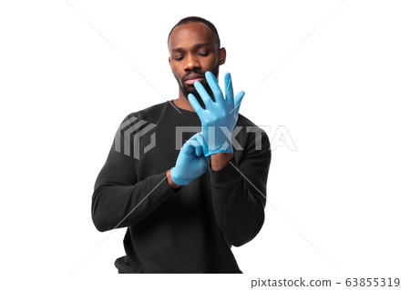How coronavirus changed our lives. Young man holding thermometer, taking temperature on white background 63855319
