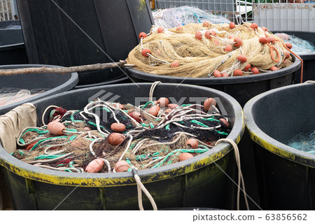 Fishing nets inside huge plastic bins close up 63856562