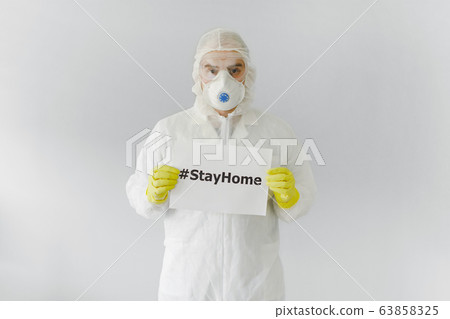 Portrait of man doctor in protective clothes during coronavirus pandemic. holding an inscription 63858325