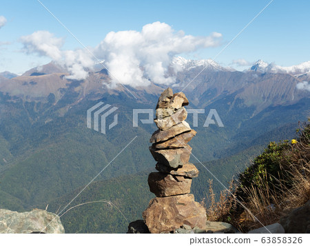 Stone pyramid on a background of a mountain range 63858326