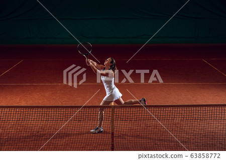 Young caucasian professional sportswoman playing tennis on sport court background Young caucasian professional sportswoman playing tennis on sport court background 63858772