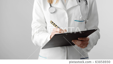 Impersonalized doctor filling medical document Impersonalized doctor filling medical document 63858930