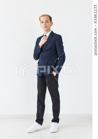 Portrait of stylish school boy teenager in white shirt and jacket against white background. Portrait of stylish school boy teenager in white shirt and jacket against white background. 63861235