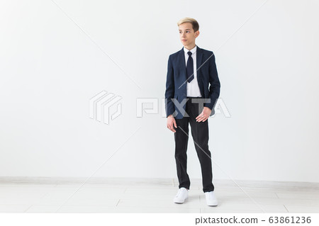 Portrait of stylish school boy teenager in white shirt and jacket against white background with copy space. Portrait of stylish school boy teenager in white shirt and jacket against white background with copy space. 63861236