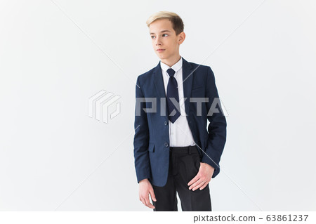Portrait of stylish school boy teenager in white shirt and jacket against white background with copy space. Portrait of stylish school boy teenager in white shirt and jacket against white background with copy space. 63861237