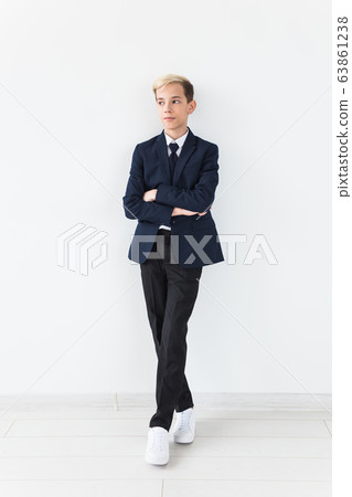 Portrait of stylish school boy teenager in white shirt and jacket against white background. Portrait of stylish school boy teenager in white shirt and jacket against white background. 63861238