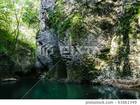 mountain river of high stone cliffs with green plants in the Martvili Canyon in Georgia mountain river of high stone cliffs with green plants in the Martvili Canyon in Georgia 63861349