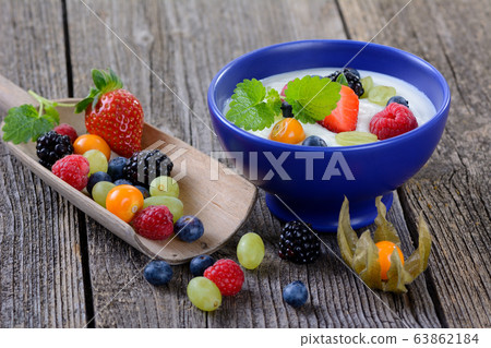 Plain yogurt with mixed fresh fruit in a blue ceramic bowl Plain yogurt with mixed fresh fruit in a blue ceramic bowl 63862184