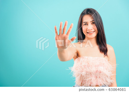 Smiling face Asian beautiful woman showing hand Smiling face Asian beautiful woman showing hand 63864081