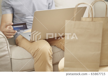 Man online shopping using laptop and back credit Man online shopping using laptop and back credit 63867715