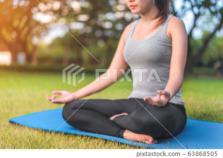 Asian woman meditating and sit in the lotus pose Asian woman meditating and sit in the lotus pose 63868505