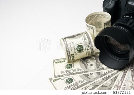 A black digital camera on banknotes with white background. 63872151