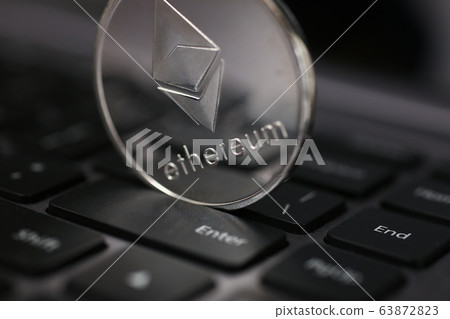 Silver ethereum coin is lying on laptop Silver ethereum coin is lying on laptop 63872823