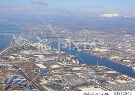 View of Tomakomai Port and the city area from the sky with Hokkaido in the winter and the mountain town of Tarumae as a background 63872842